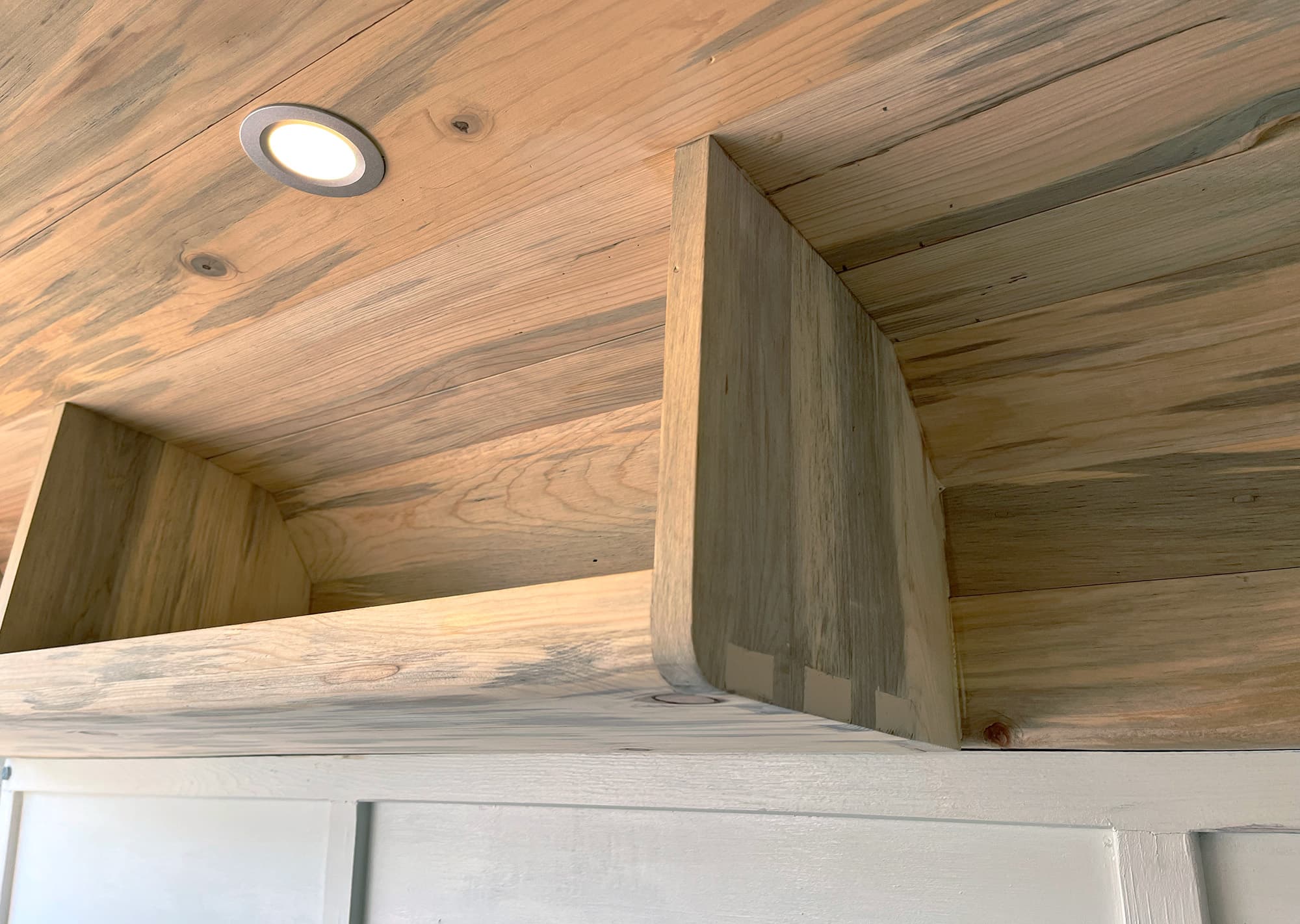 Image of dovetail blue pine cabinets in a van. Never mind the wood filler to make it even